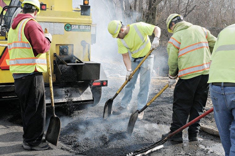 PennDot workers attack potholes along Business Route 1 in Penndel on Wednesday March 11, 2015. The crew has been playing catch up this week trying to get the most dangerous ones finished first and then hit the rest.