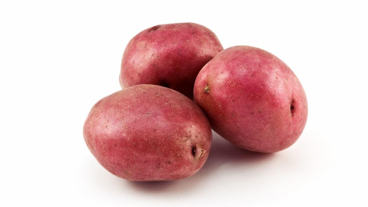 three red potatoes on a white background