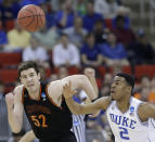 Duke guard Quinn Cook (2) and Mercer forward Daniel Coursey (52) vie for a loose ball during the first half of an NCAA college basketball second-round game, Friday, March 21, 2014, in Raleigh, N.C. (AP Photo/Gerry Broome)
