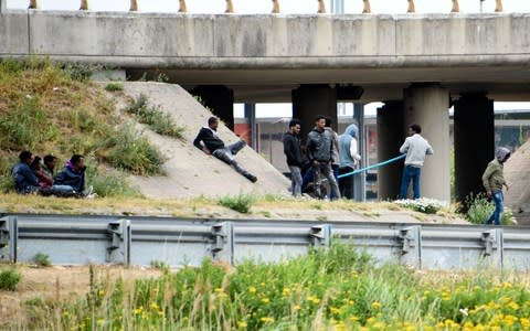 Migrants wait on the roadside along the ring road leading to the port of Calais in July 2017 - Credit: DENIS CHARLET/AFP