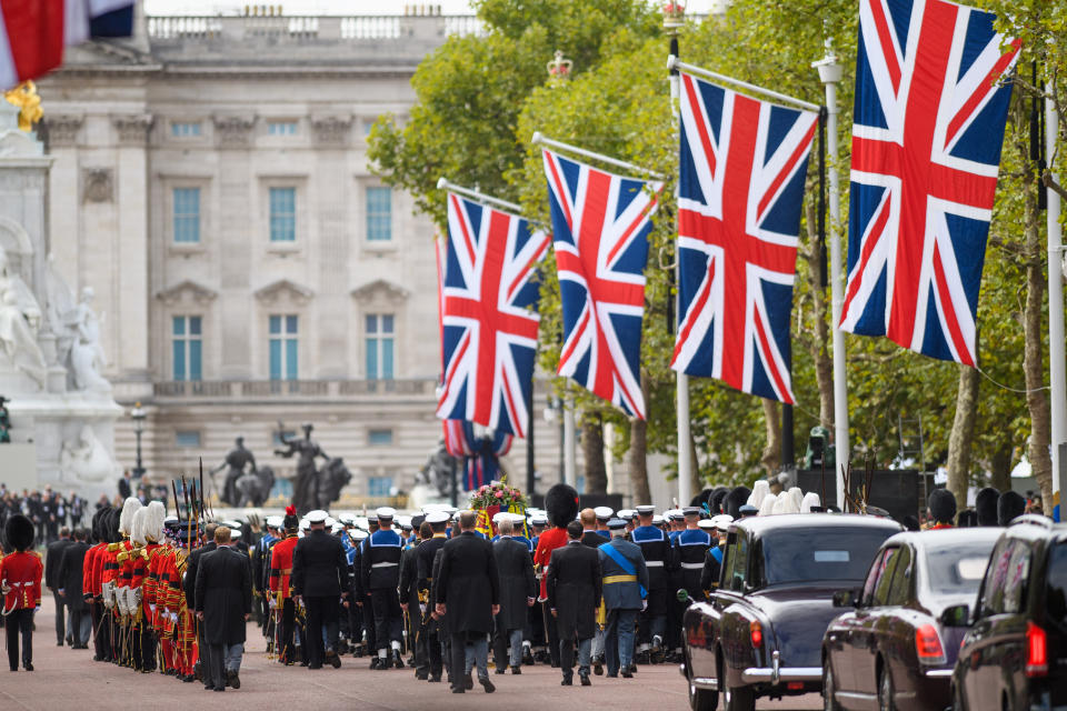 The State Gun Carriage carries the coffin of Queen Elizabeth II, draped in the Royal Standard with the Imperial State Crown and the Sovereign's orb and sceptre, in the Ceremonial Procession down The Mall, following her State Funeral at Westminster Abbey, London. Picture date: Monday September 19, 2022. Photo credit should read: Matt Crossick/Empics