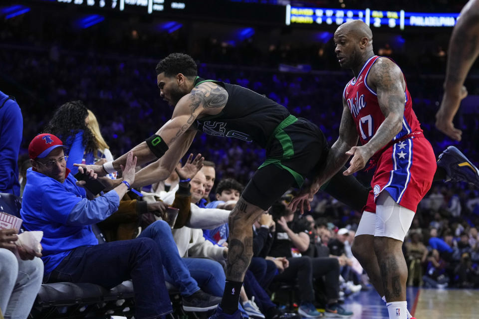 Boston Celtics' Jayson Tatum, center, goes into the audience as Philadelphia 76ers' P.J. Tucker, right, watches during the second half of Game 3 in an NBA basketball Eastern Conference semifinals playoff series, Friday, May 5, 2023, in Philadelphia. (AP Photo/Matt Slocum)