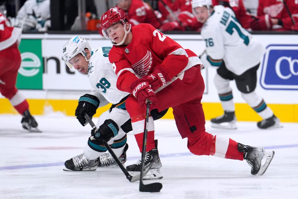 San Jose Sharks center Logan Couture (39) battles for the puck against Detroit Red Wings left wing Lucas Raymond (23) during the first period of an NHL hockey game Tuesday, Jan. 11, 2022, in San Jose, Calif.