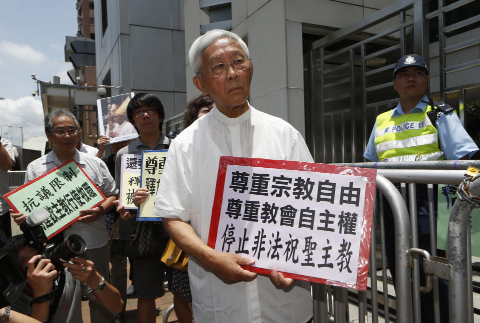 FILE - Hong Kong's outspoken cardinal Joseph Zen, center, and other religious protesters hold placards with "Respects religious freedom" written on them during a demonstration outside the China Liaison Office in Hong Kong, Wednesday, July 11, 2012. Reports say a Roman Catholic cardinal and three others have been arrested in Hong Kong on suspicion of colluding with foreign forces to endanger Chinese national security. U.K.-based human rights group Hong Kong Watch said Cardinal Joseph Zen, lawyer Margaret Ng, singer Denise Ho and scholar Hui Po-keung were detained Wednesday, , May 11, 2022, by Hong Kong's National Security Police. (AP Photo/Kin Cheung, File)