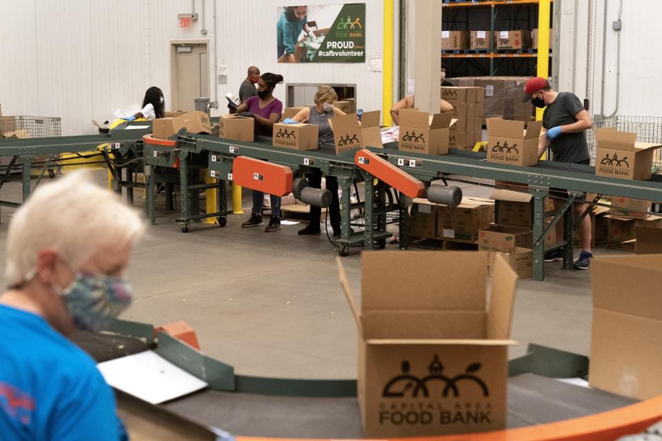 Volunteers pack boxes of food for distribution, at The Capital Area Food Bank, Tuesday, Oct. 5, 2021, in Washington. (AP Photo/Jacquelyn Martin)