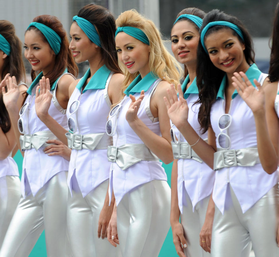 Grid girls pose for photographers during the drivers' grid introductory ceremony prior to the start of Formula One's Malaysian Grand Prix at the Sepang International Circuit in Sepang on March 25, 2012.  AFP PHOTO / ROSLAN RAHMAN (Photo credit should read ROSLAN RAHMAN/AFP/Getty Images)