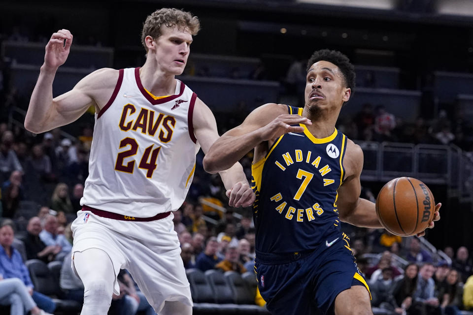 Indiana Pacers guard Malcolm Brogdon (7) drives on Cleveland Cavaliers forward Lauri Markkanen (24) during the second half of an NBA basketball game in Indianapolis, Tuesday, March 8, 2022. The Cavaliers won 127-124. (AP Photo/Michael Conroy)