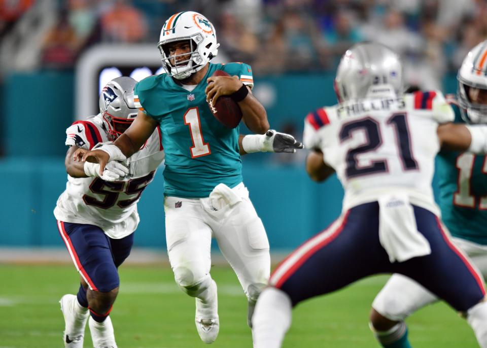 QB Tua Tagovailoa runs for a first down vs. the Patriots. The Dolphins open at home vs. New England this season.