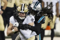 New Orleans Saints quarterback Taysom Hill is tackled by Carolina Panthers free safety Tre Boston during the first half of an NFL football game Sunday, Jan. 3, 2021, in Charlotte, N.C. (AP Photo/Brian Blanco)