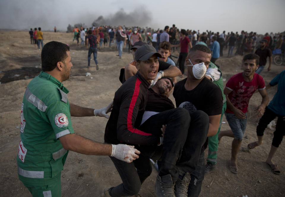 Palestinians evacuate a wounded protester at the Gaza Strip's border with Israel, Friday, Oct. 19, 2018. (AP Photo/Khalil Hamra)