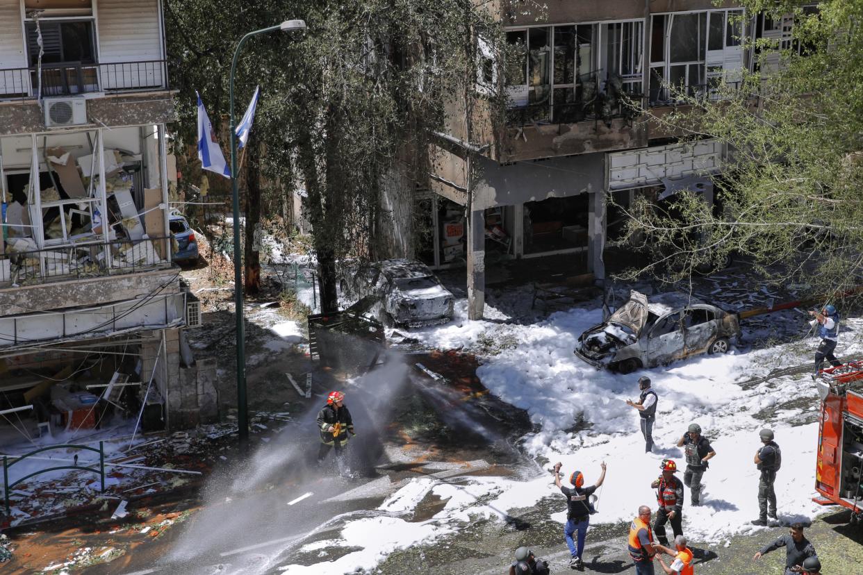 Israeli security forces and emergency services work on a site hit by a rocket fired from the Gaza Strip in Ramat Gan, central Israel, on Saturday, May 15, 2021.