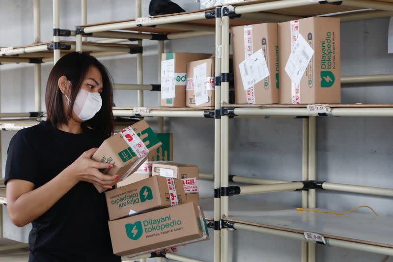 An employee packs goods at Goto's e-commerce unit Tokopedia's warehouse in Jakarta