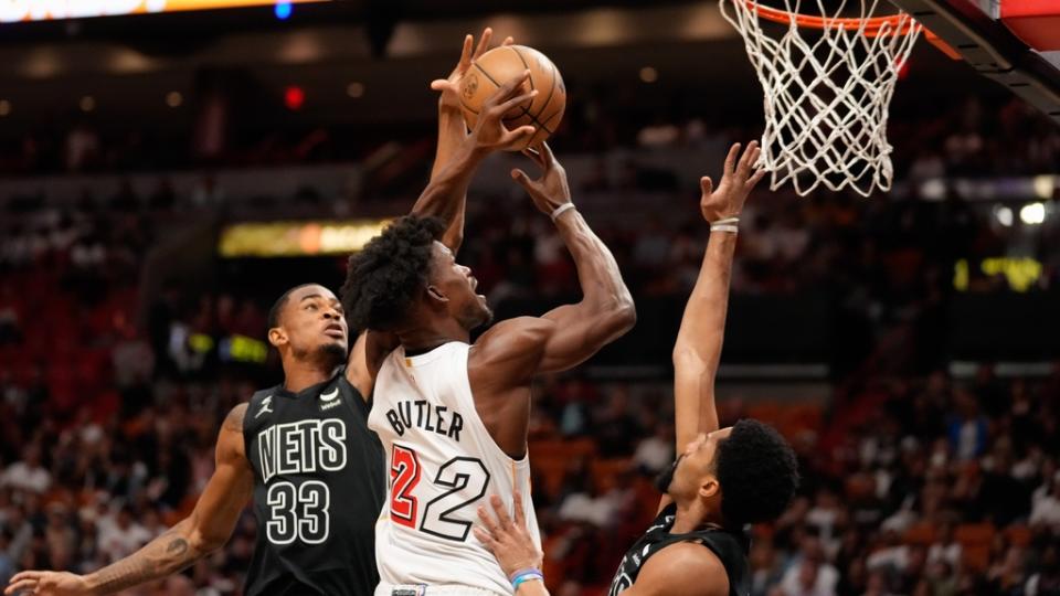 Mar 25, 2023;  Miami, Florida, USA;  Brooklyn Nets center Nic Claxton (33) fouls Miami Heat forward Jimmy Butler (22) during the first quarter at Miami-Dade Arena.