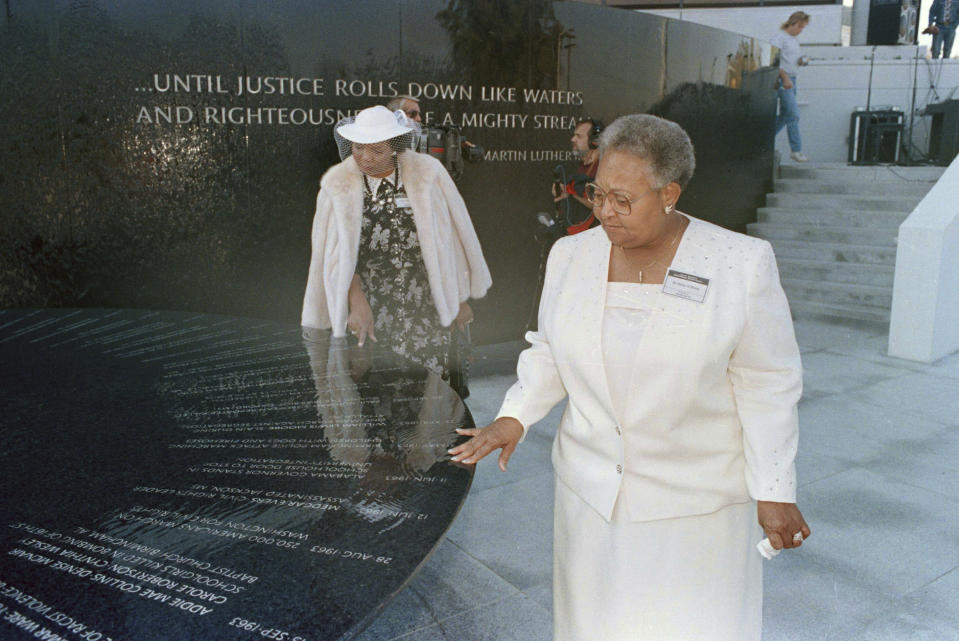 FILE - Mamie Till-Mobley, mother of lynching victim Emmett Till, right, and Wilma Allen of New Orleans search for their relatives' names on the black granite table at the Civil Rights Memorial in Montgomery, Ala., Nov. 5, 1989. The memorial is located at the Southern Poverty Law Center. (AP Photo/Dave Martin, File)