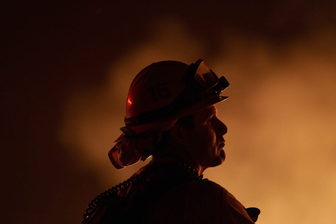 A firefighter watches flames from the Rabbit Fire along Gilman Springs Road late Friday, July 14, 2023, in Moreno Valley, Calif. (AP Photo/Eric Thayer)
