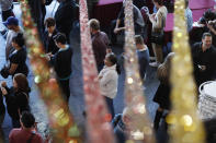 People wait in line at an early voting location in the Chinatown Plaza, Saturday, Feb. 15, 2020, in Las Vegas. (AP Photo/John Locher)