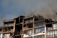 Smoke rises over a residential building damaged by a Russian missile strike, in Kyiv