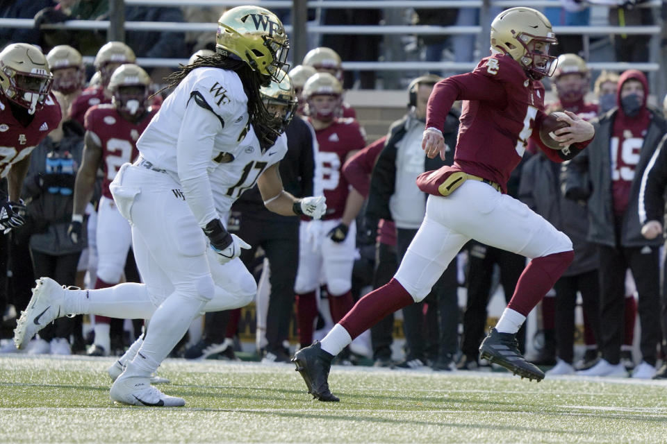 Boston College quarterback Phil Jurkovec (5) rushes ahead of Wake Forest defenders during the first half of an NCAA college football game, Saturday, Nov. 27, 2021, in Boston. (AP Photo/Mary Schwalm)