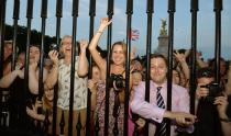 The large waiting crowds cheers as the Queen's Press Secretary Ailsa Anderson with Badar Azim a footman place on an easel in the Forecourt of Buckingham Palace a notification, to announce the birth of a baby boy, at 4.24pm to the Duke and Duchess of Cambridge at St Mary's Hospital in west London.