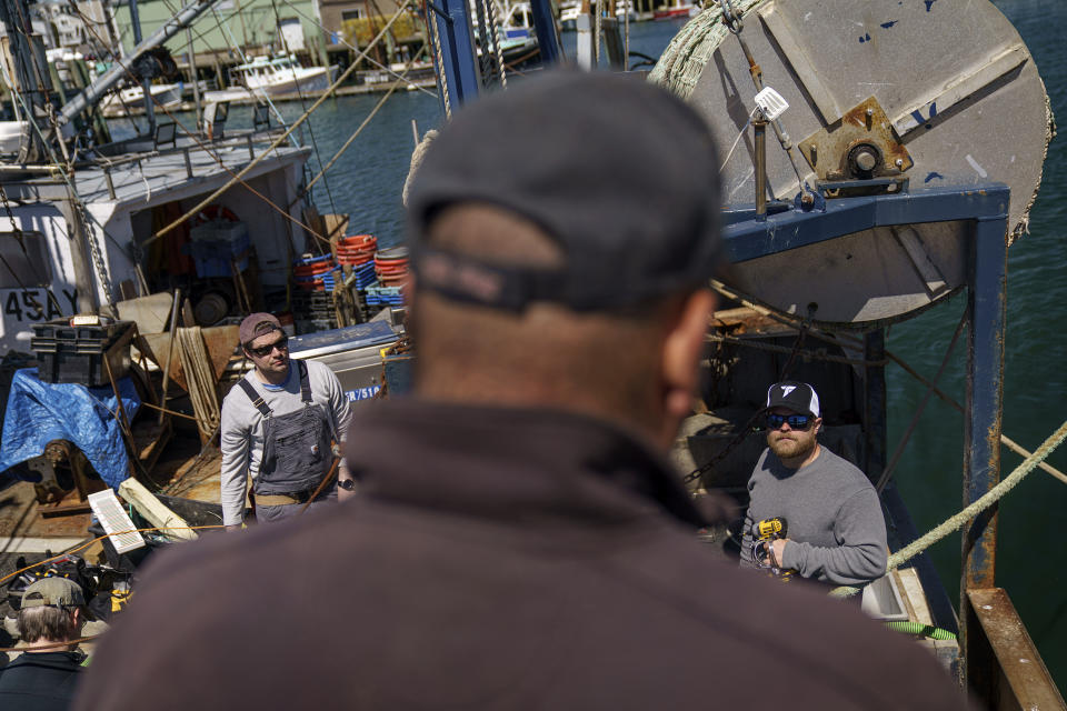 Mark Hager, right, and Anthony Lucia, talk with captain Al Cottone as they install cameras on his fishing boat, the Sabrina Marina, in Gloucester, Mass., May 11, 2022. "This isn't your grandfather's fishery anymore," said Cottone, who recently had cameras installed on his 45-foot groundfish trawler. "If you're going to sail, you just turn the cameras on and you go." (AP Photo/David Goldman)