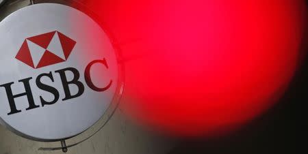 A traffic light shines red near the HSBC bank logo, pictured at the bank buidling in Paris, June 15, 2015. REUTERS/Christian Hartmann