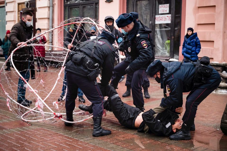 Police officers detain opposition activist Pavel Krysevich, on the ground, after his action in support of Russian opposition leader Alexei Navalny and against the mass arrests at Saturday's uncoordinated rally in Moscow, Russia, Sunday, Jan. 24, 2021. Krisevich locked himself in a sphere covered with barbed wire in Moscow's centre protesting the arrest of Russian opposition leader and mass detentions during Saturday's protests. Krisevich and several of other activists were detained shortly after the start of the action. (AP Photo/George Markov)