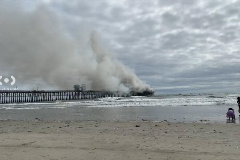 Oceanside pier engulfed in flames. Firefighters work to extinguish blaze