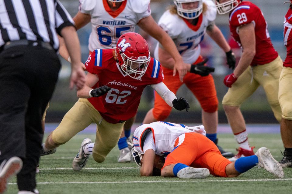 Whiteland High School junior Kevin Denham (17) covers up a recovered fumble as Martinsville High School senior Nic Crone (62) closes in on him during the first half of an IHSAA varsity football game, Friday, Sept. 23, 2022, at Martinsville High School.