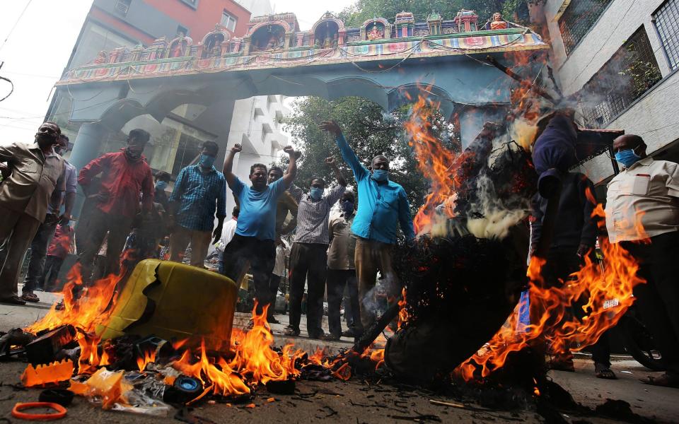 Activists burn photos of Chinese President Xi Jinping during a protest in Bangalore in June - JAGADEESH NV/EPA-EFE/Shutterstock