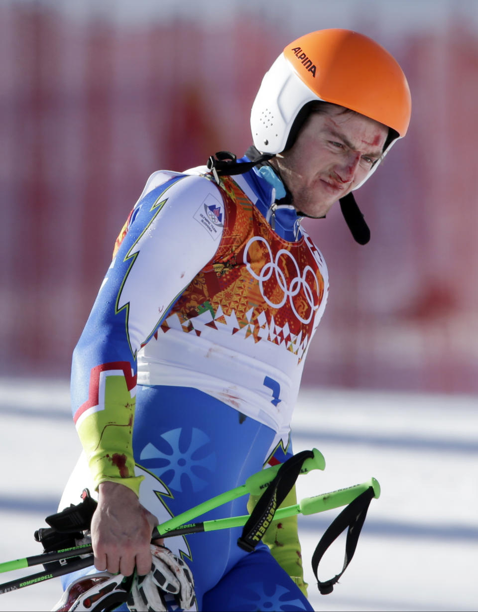 Slovenia's Rok Perko arrives in the finish area after crashing during a men's downhill training run for the Sochi 2014 Winter Olympics, Saturday, Feb. 8, 2014, in Krasnaya Polyana, Russia. (AP Photo/Gero Breloer)