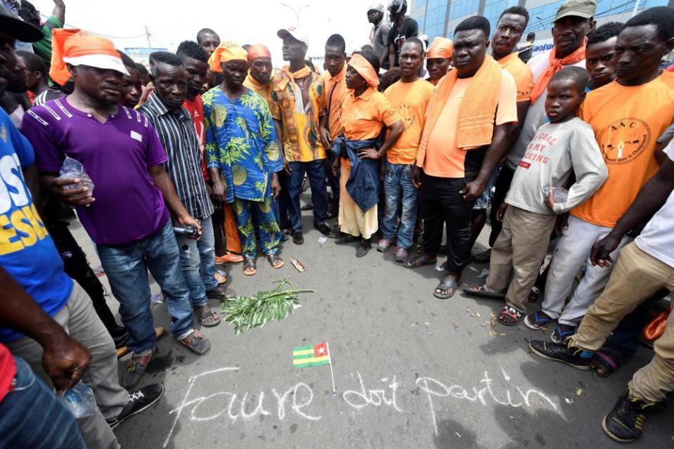 Anti-government protesters in Lomé gather around a scrawled message saying: ‘Faure should leave’