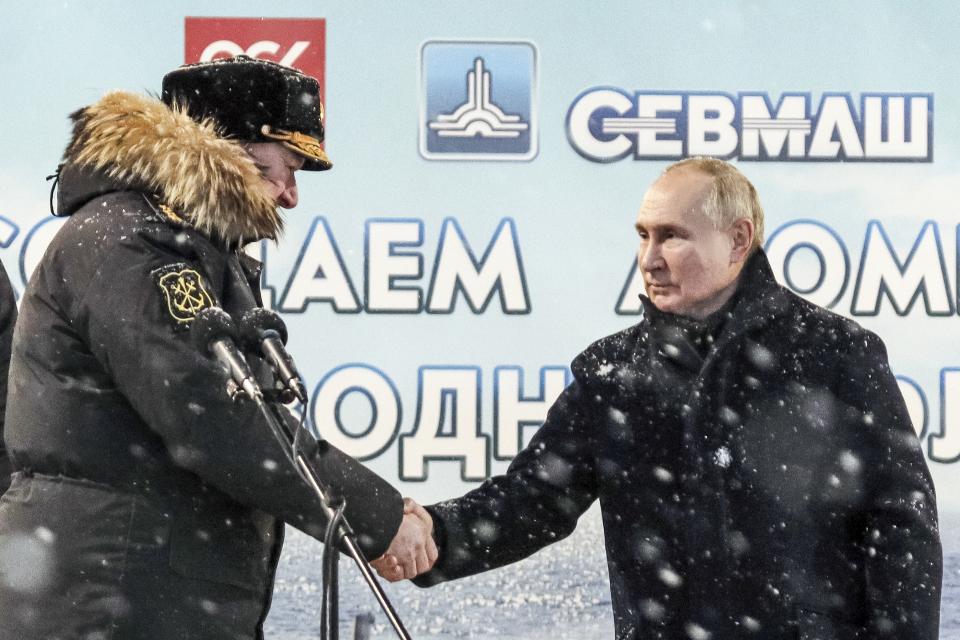 Russian President Vladimir Putin, right, shakes hands with Admiral Nikolai Yevmenov, Commander-in-Chief of the Russian Navy as he attends a flag-raising ceremony for newly-built nuclear submarines at the Sevmash shipyard in Severodvinsk in Russia's Archangelsk region, Monday, Dec. 11, 2023. The navy flag was raised on the Emperor Alexander III and the Krasnoyarsk submarines during Monday's ceremony. Putin has traveled to a northern shipyard to attend the commissioning of new nuclear submarines, a visit that showcases the country's nuclear might amid the fighting in Ukraine. (Kirill Iodas, Sputnik, Kremlin Pool Photo via AP)