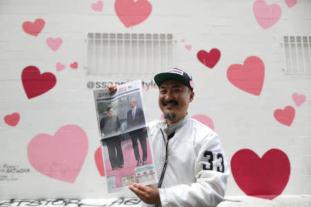 Ssoonie Kim, 45, poses in front of his beauty store with a newspaper with a front page story about the inter-Korean summit between North Korea's Kim Jong Un and South Korean President Moon Jae-in, in Koreatown, Los Angeles, California, April 27, 2018. REUTERS/Lucy Nicholson