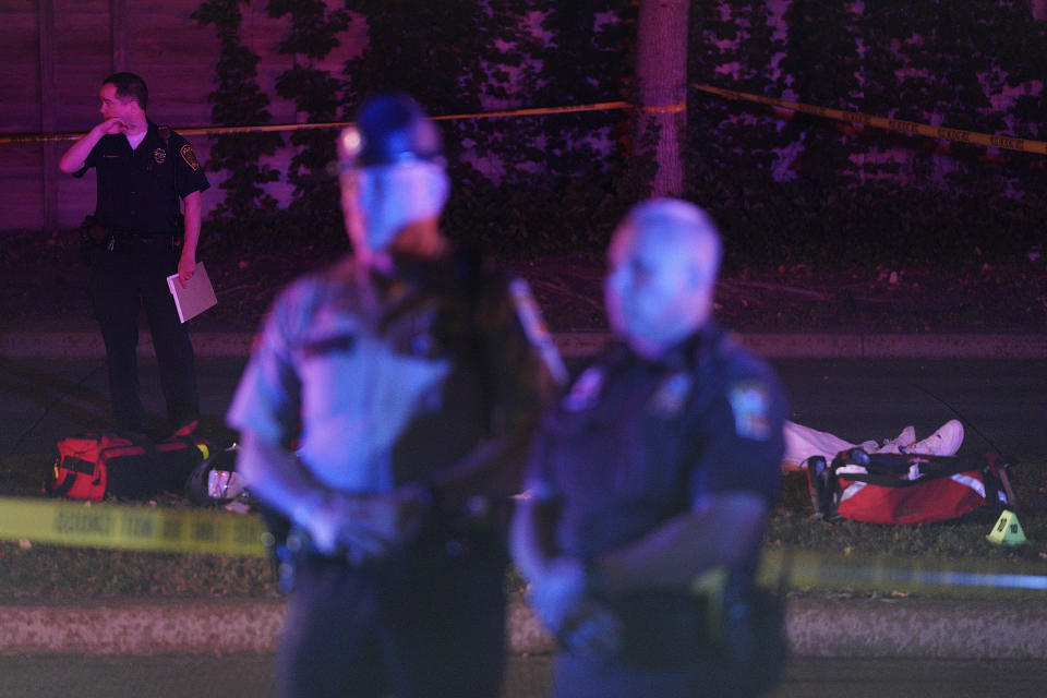 Police stand in front of a body at the scene of an officer involved shooting on East 77th Street in Richfield, Minn., Saturday night, Sept. 7, 2019. Police near Minneapolis shot and killed a driver following a chase after he apparently emerged from his car holding a knife and refused their commands to drop it. The chase started late Saturday night in Edina and ended in Richfield with officers shooting the man, Brian J. Quinones, who had streamed himself live on Facebook during the chase. (Anthony Souffle/Star Tribune via AP)
