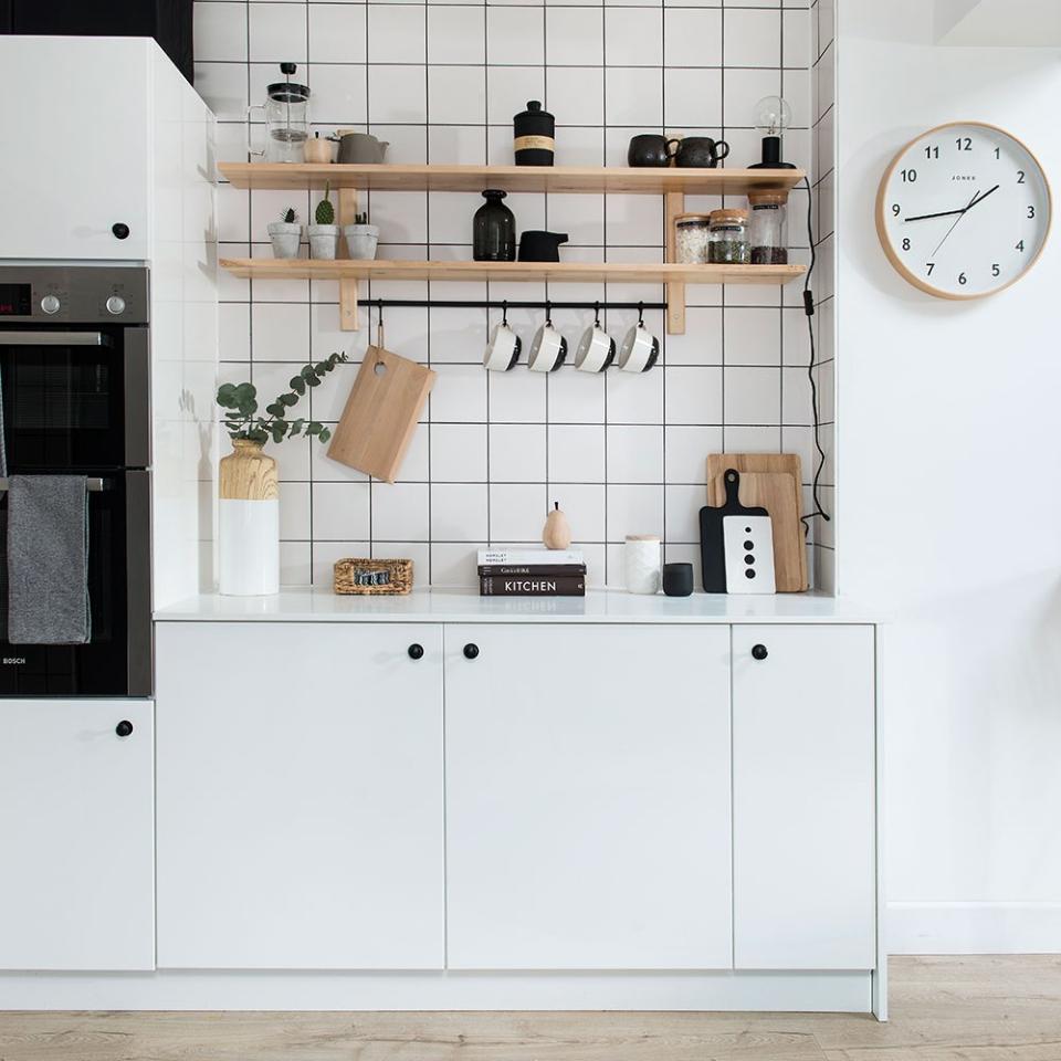 white kitchen with black accents and wooden wall shelves