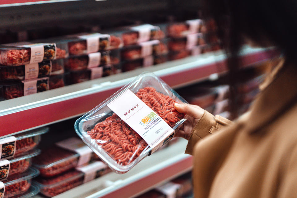 a person holding a pack of ground beef