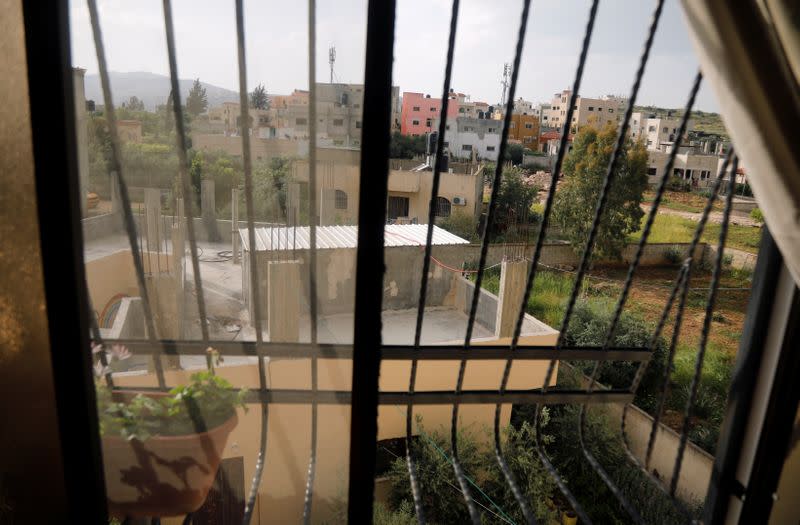 Houses are seen through the window of the family apartment of Palestinian boy Belal Daraghma in Tubas