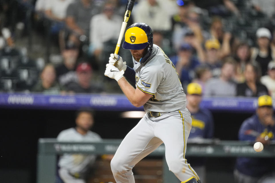 The ball bounces off Milwaukee Brewers' Rhys Hoskins after he was hit by a pitch with the bases loaded to force in the go-ahead run while facing Colorado Rockies relief pitcher Justin Lawrence in the ninth inning of a baseball game Tuesday, July 2, 2024, in Denver. (AP Photo/David Zalubowski)