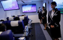 Staff dressed as flight attendants, greet guests at the "First Airlines", virtual first-class airline experience facility in Tokyo, Japan February 14, 2018. Picture taken February 14, 2018. REUTERS/Toru Hanai