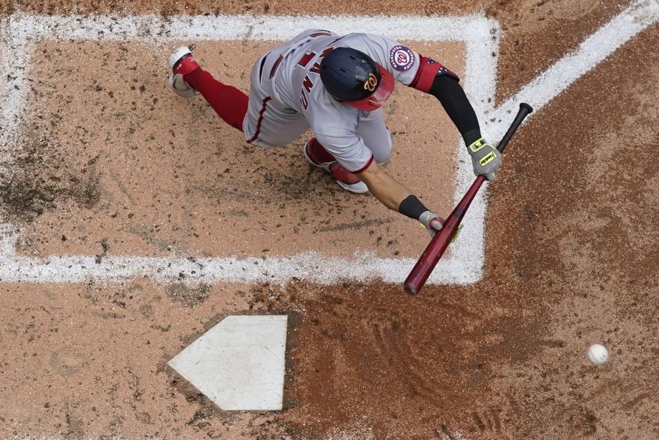 Washington Nationals' Cesar Hernandez bunts for an RBI single during the fourth inning of a baseball game against the Milwaukee Brewers Sunday, May 22, 2022, in Milwaukee. (AP Photo/Morry Gash)