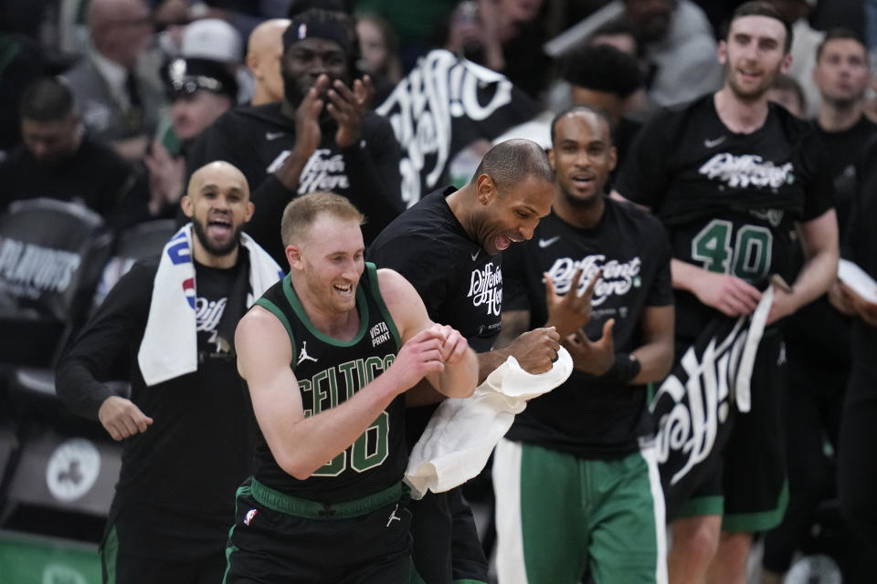 Boston Celtics forward Sam Hauser (30) is congratulated after hitting a 3-pointer against the Miami Heat during the second half of Game 5 of an NBA basketball first-round playoff series, Wednesday, May 1, 2024, in Boston. (AP Photo/Charles Krupa)