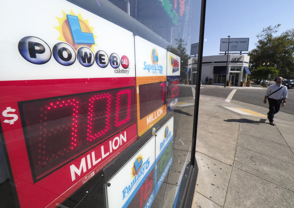 <p>A pedestrian walks by a liquor store displaying a Powerball sign in Oakland, Calif., on Aug. 23, 2017. The Powerball lottery has risen to 700 million US dollars making it one of the largest in history. (Photo: John G. Mabanglo/EPA/REX/Shutterstock) </p>