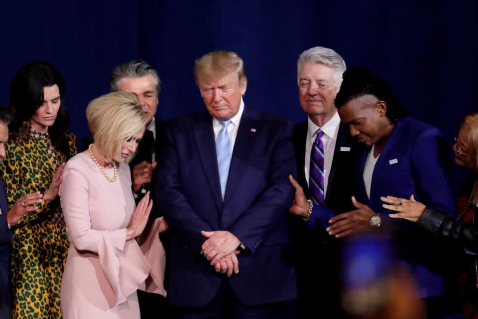 Pastor Paula White, left, and other faith leaders pray with President Donald Trump, center, during a rally for evangelical supporters at the King Jesus International Ministry church, Friday, Jan. 3, 2020 (Copyright 2020 The Associated Press. All rights reserved.)