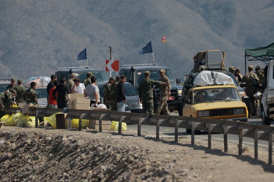 Ethnic Armenians from Nagorno-Karabakh and European Union observers drive their cars past a checkpoint on the road from Nagorno-Karabakh to Armenia’s Goris (AP)