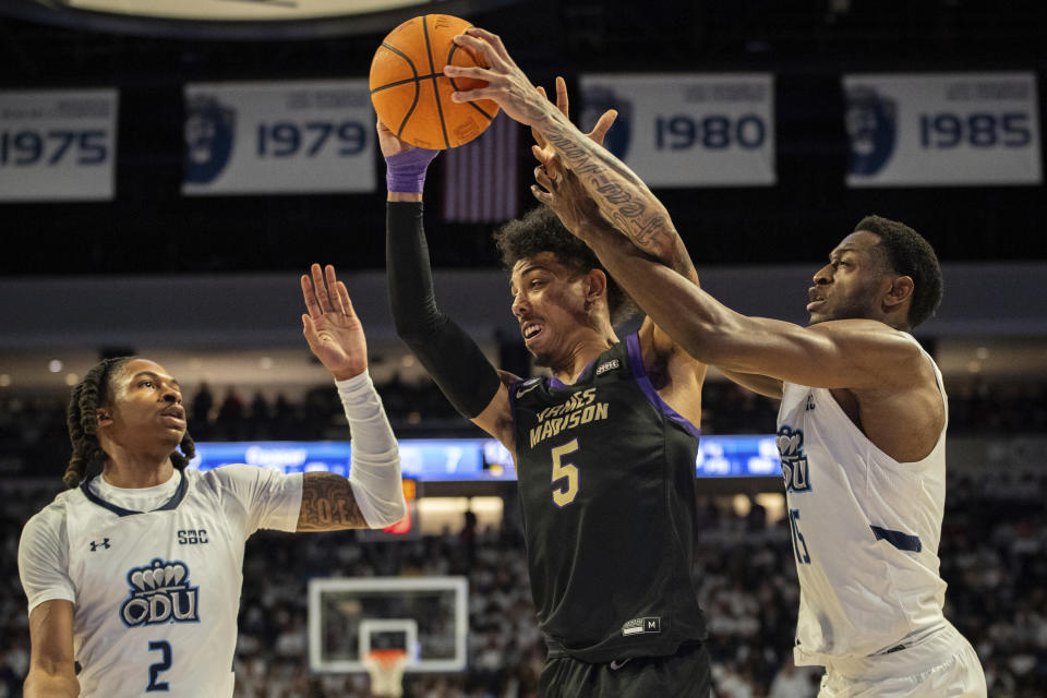 James Madison guard Terrence Edwards (5) maneuvers past Old Dominion guards Chaunce Jenkins (2) and R.J. Blakney (15) during the first half of an NCAA college basketball game Saturday, Dec. 9, 2023, in Norfolk, Va. (AP Photo/Mike Caudill)