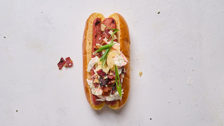 hot dog with coleslaw, bacon and potato chips