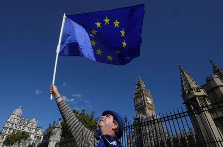 A protestor waves an EU flag as he walks past the Houses of Parliament in central London, Britain September 22, 2017. REUTERS/Toby Melville/Files