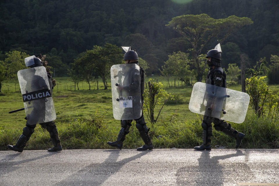 Security forces block Honduran migrants in San Luis Peten, Guatemala, Saturday, Oct. 3, 2020. Early Saturday, hundreds of migrants who had entered Guatemala this week without registering were being bused back to their country's border by authorities after running into a large roadblock. (AP Photo/Moises Castillo)