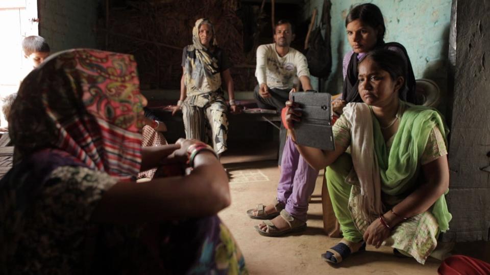 An Indian woman records an interview on her phone