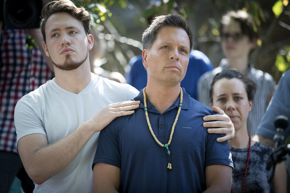 Don Damond is comforted by his son Zach Damond before making a statement to the press near his home after Minneapolis police officer shot and killed his fiance Justine, Monday, July 17, 2017 in Minneapolis, Minn. Relatives and neighbors of the Australian woman who was fatally shot by Minneapolis police over the weekend demanded answers about the mysterious shooting in which the meditation teacher and bride-to-be was reportedly killed by a bullet fired through a squad-car door. (Elizabeth Flores/Star Tribune via AP)